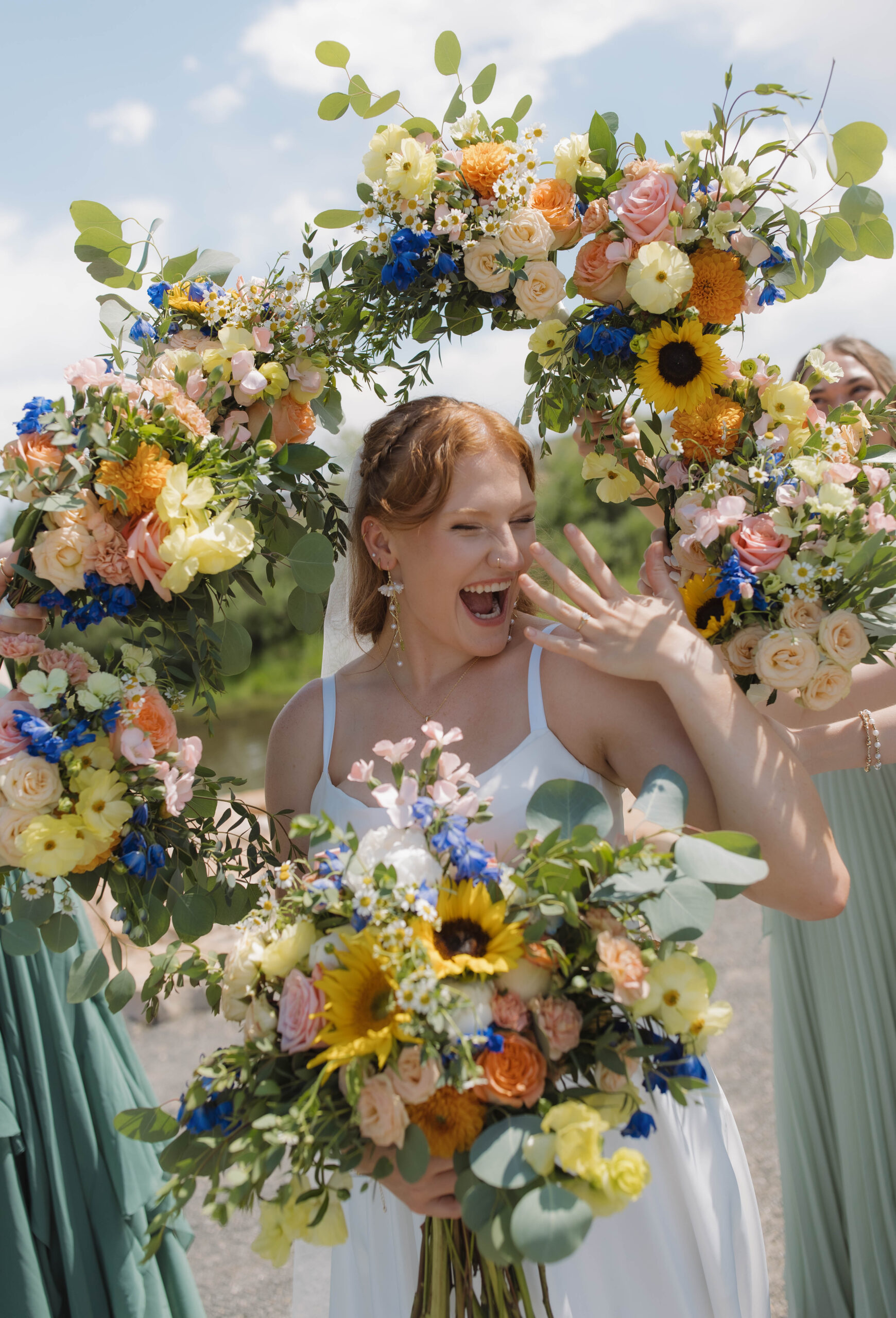 Lush garden ceremony floral arch bursting with peach, cream, and blush roses